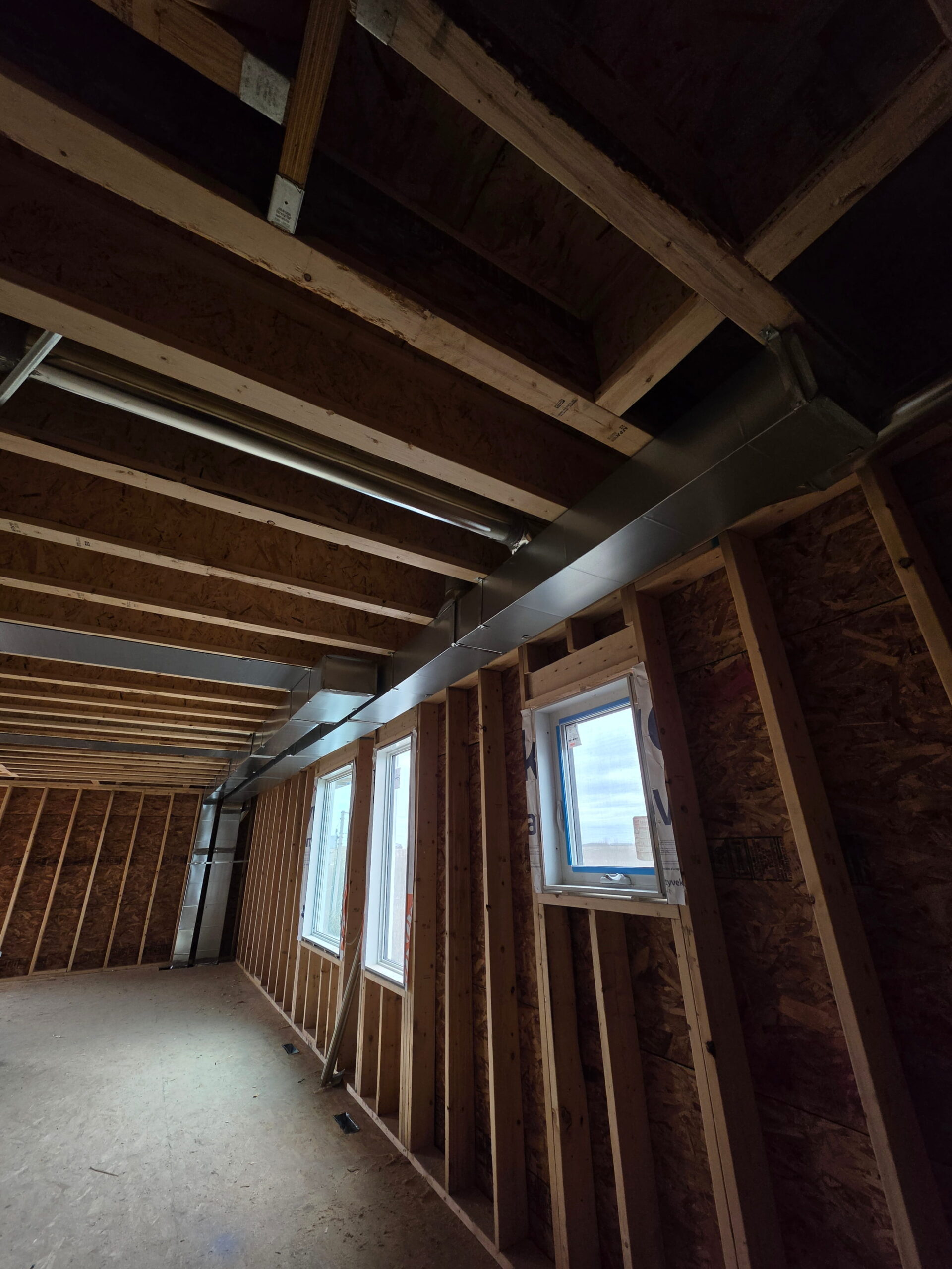 Exposed custom ventilation ducts expertly routed through a new construction project in Calgary.